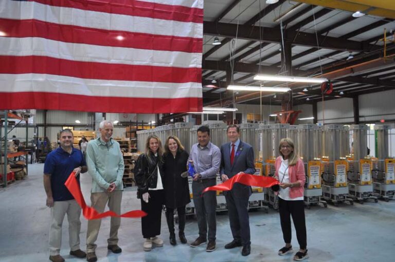 Senator Norm Needleman (D-CT33) and Senator Richard Blumenthal (D-CT) stand with members of the Weinstein family and representatives from Middlesex Chamber of Commerce under an american flag - celebrating 60 years contributing to Connecticut's critical manufacturing base.
