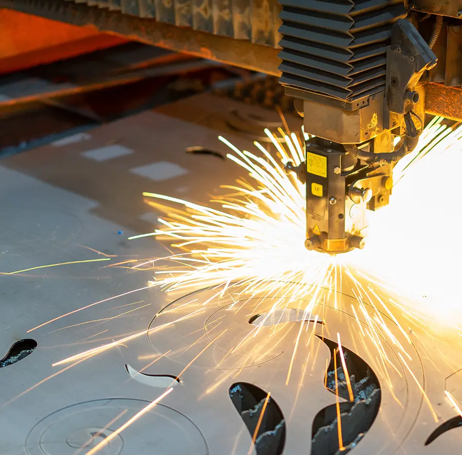 Industrial laser cutter at work, cutting a metal sheet with bright sparks flying from the cut.